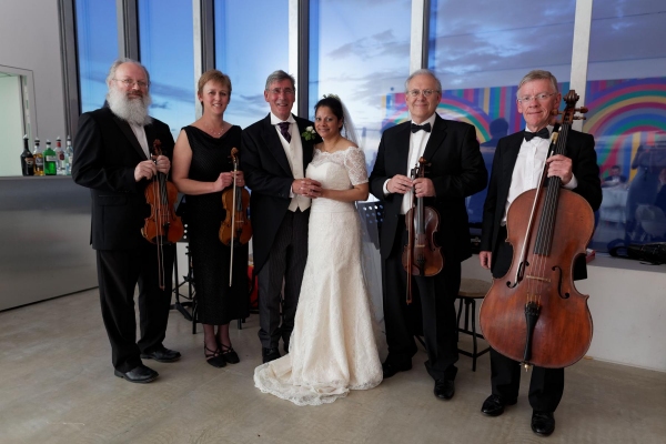 Bride and groom flanked by four musicians