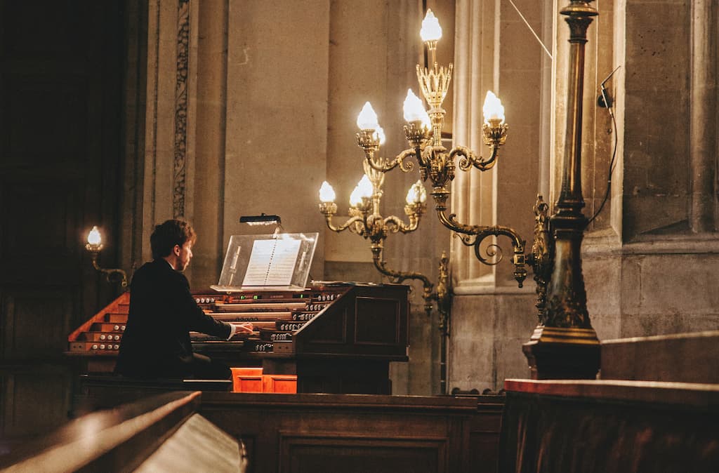 Organist at the console in a dark church